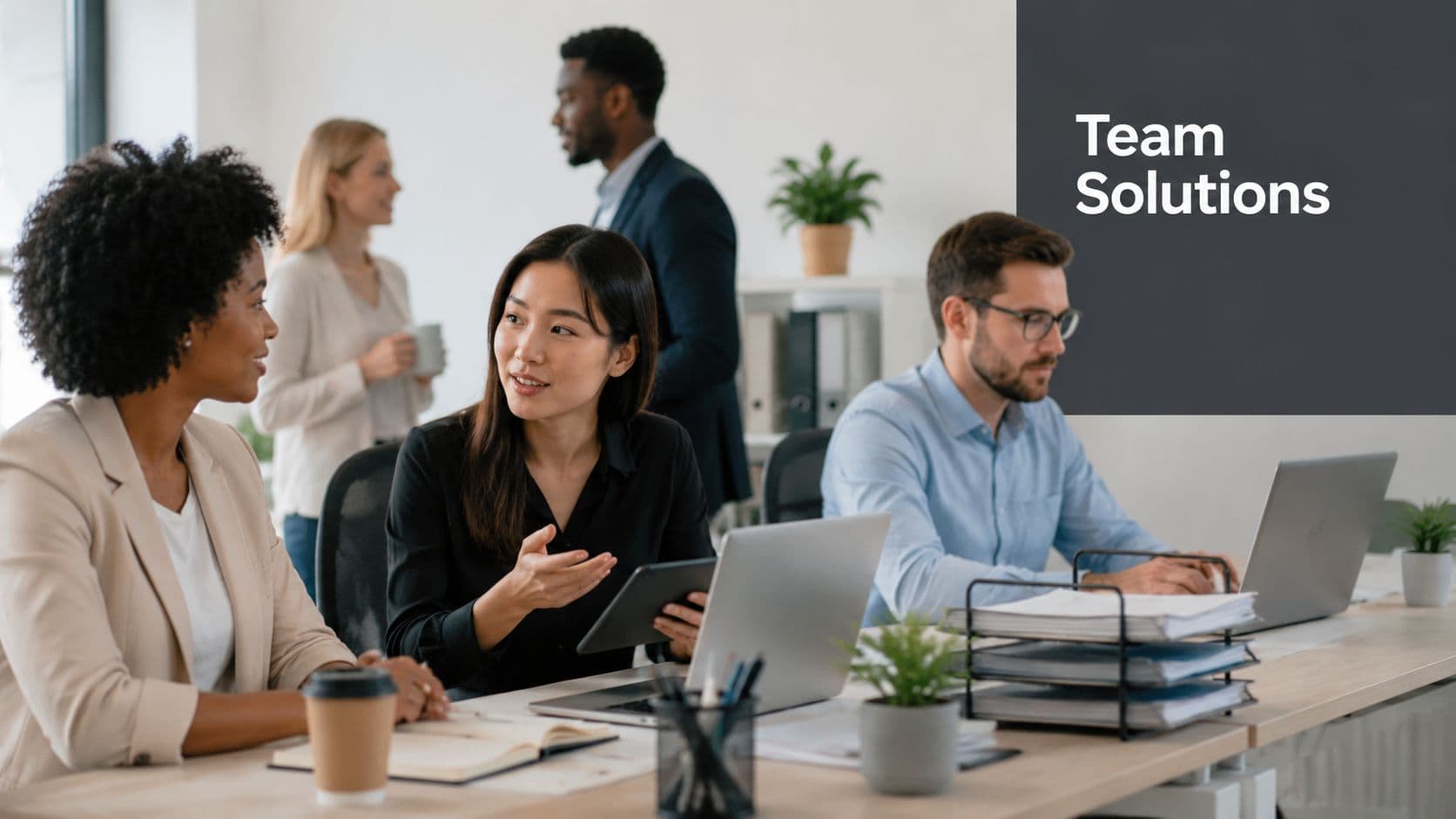 A diverse group of professionals working collaboratively in a bright, modern office, engaged in a team meeting.